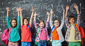 Kinder strecken die Arme hoch vor einer Wandtafel.