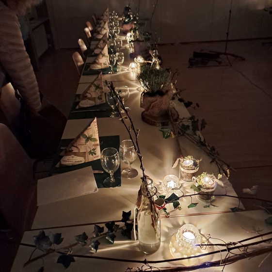 dekorierter Tisch mit Lichtern, Krutern und Eveu
