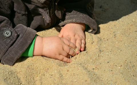 Kinderhnde im Sand.